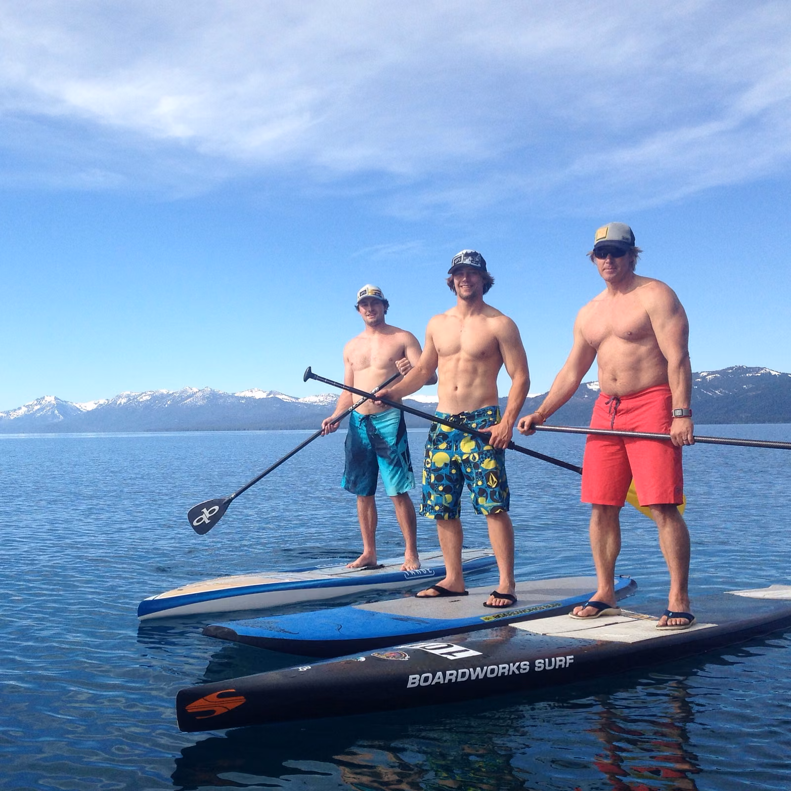 Three paddleboarders on the clear blue water of Lake Tahoe