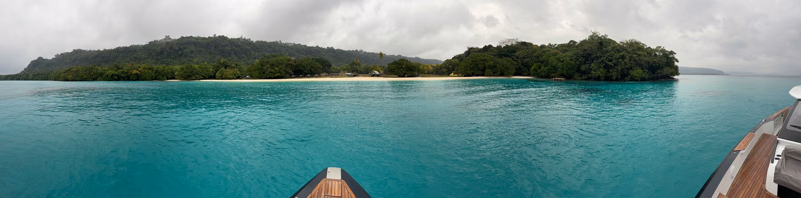 A low green island across turquoise water in Vanuatu