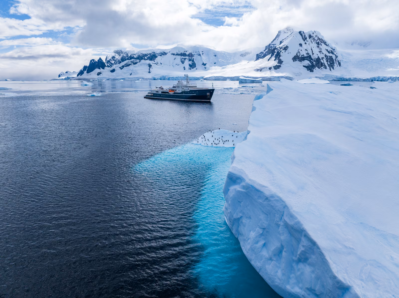 Turquoise ice beneath the surface beside a glacier front