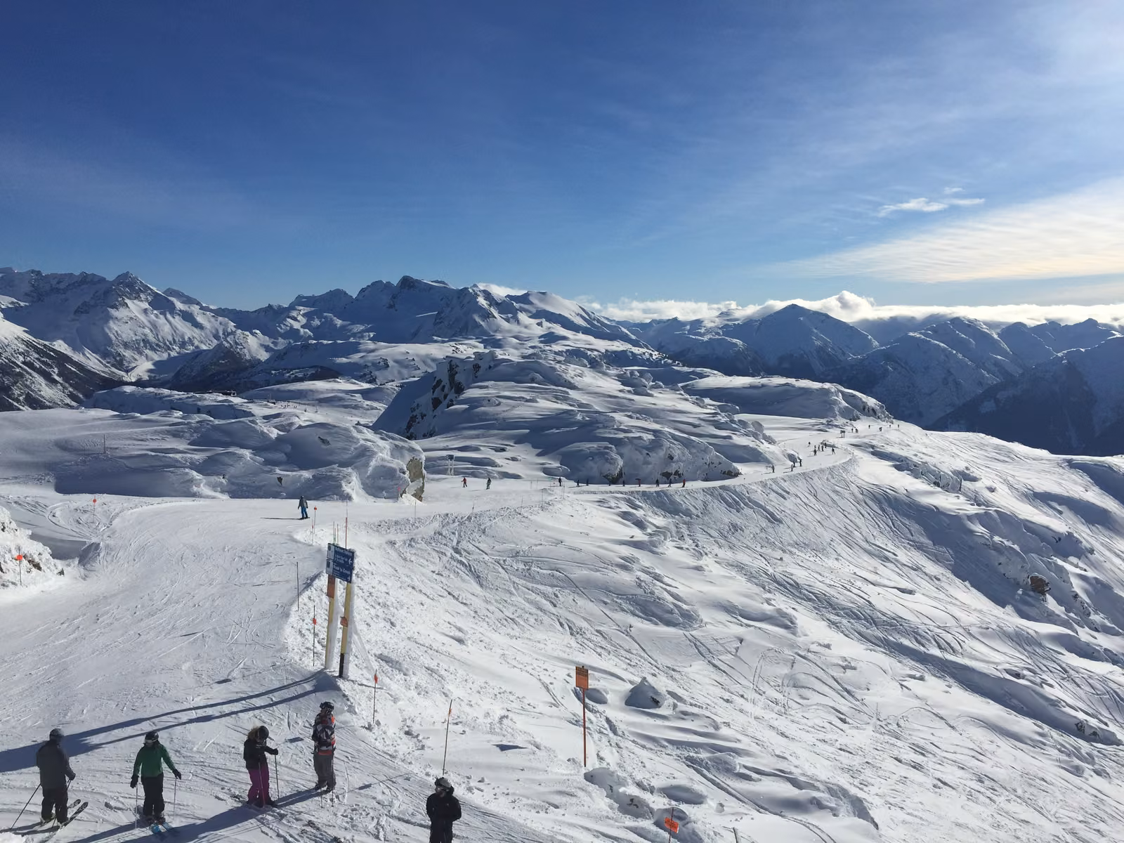 Skiers on a wide alpine bowl high on Whistler