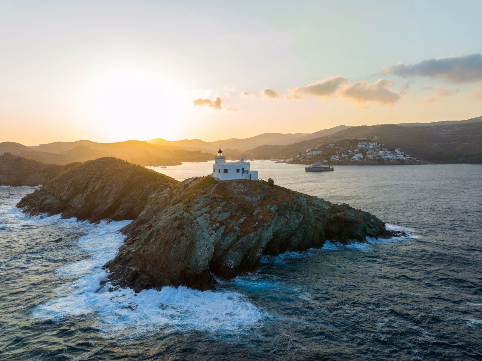 Surf breaking around a Kea headland in low gold light